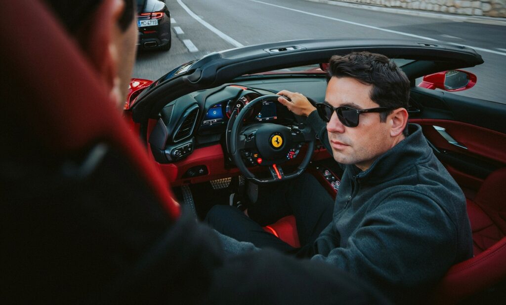 A man with sunglasses drives a vibrant red sports car, highlighting a dynamic and adventurous lifestyle Monaco offers.