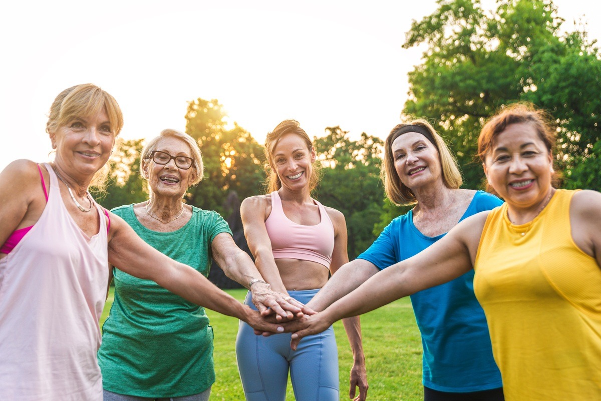 Multiethnic group of senior women training at park with fitness instructor - Active elderly people doing sport in the nature. Multiethnic group of senior women training at park with fitness instructor - Active elderly people doing sport in the nature