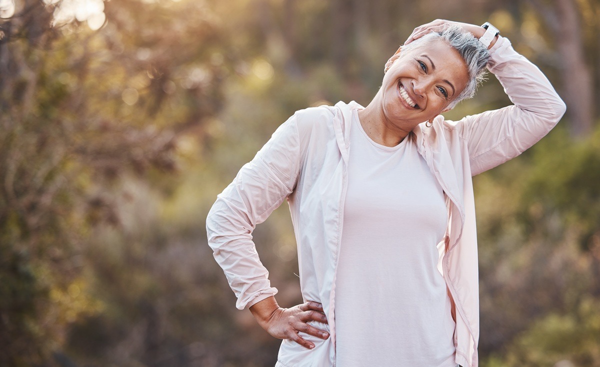 Woman exercising and stretching neck for at a park. Woman exercising and stretching neck for at a park.