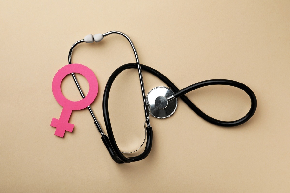 Female gender sign and stethoscope on beige background, flat lay. Female gender sign and stethoscope on beige background, flat lay.