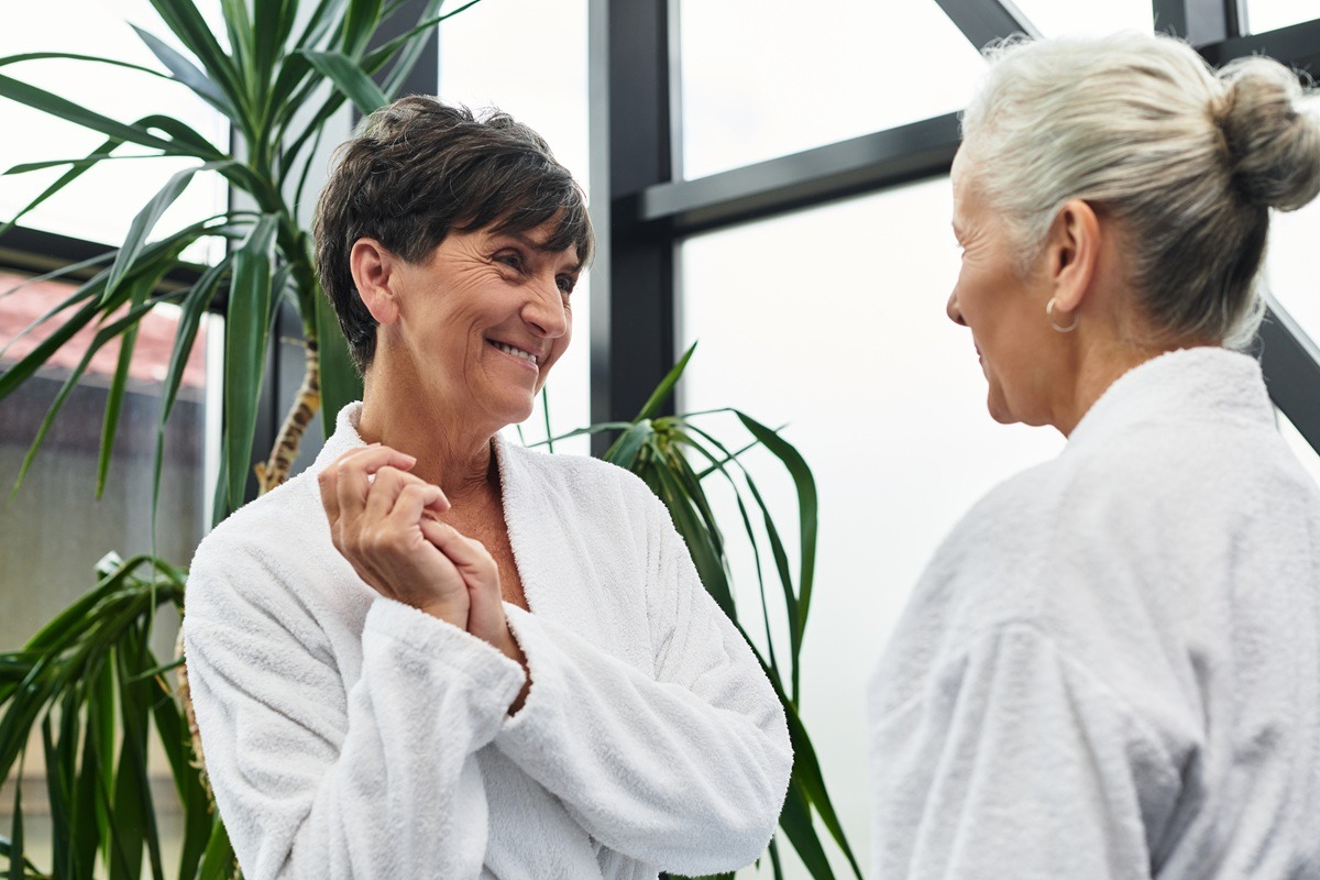Two mature women share joyful conversation in a wellness center focusing on self-care. Two mature women share joyful conversation in a wellness center focusing on self-care.