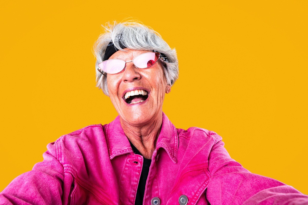 Beautiful senior woman with gray hair portrait in studio behind a yellow background. Beautiful senior woman with gray hair portrait in studio