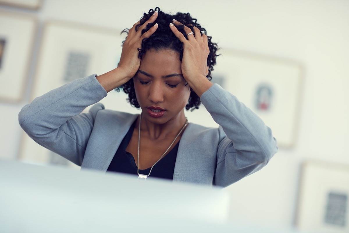 A woman holding her head and frustrated.