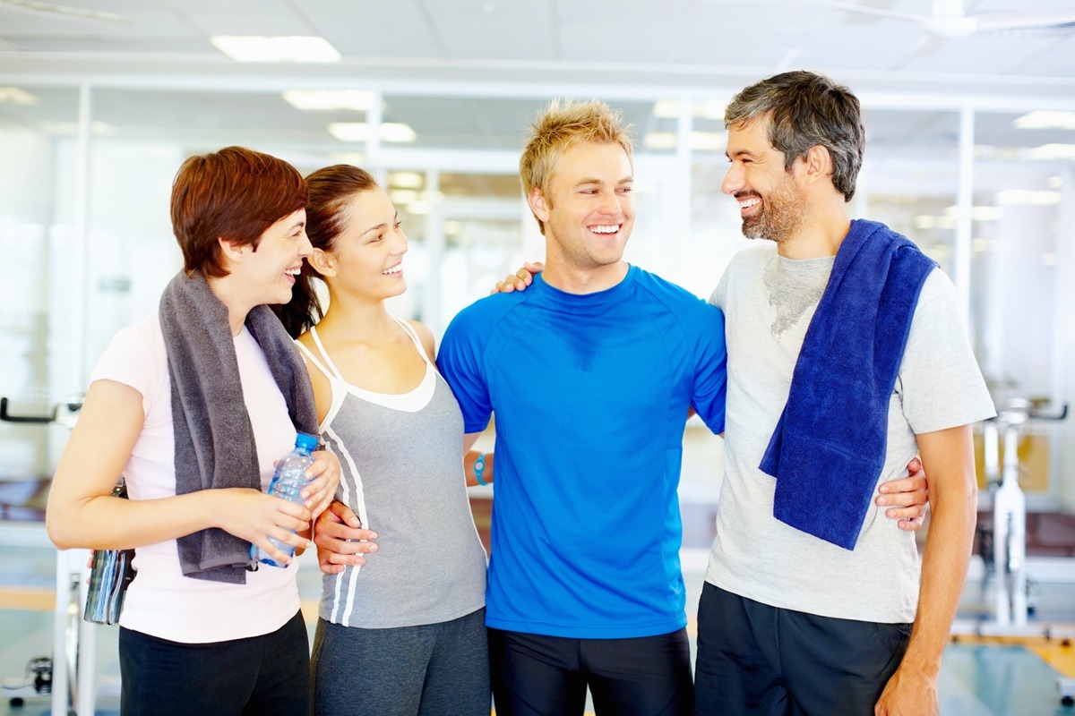 Happy men and women at fitness center. Men and women after a workout together.