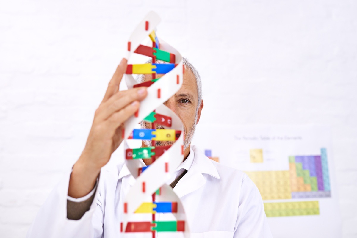 An image of a person holding a colourful DNA double helix model. An image of a person holding a colourful DNA double helix model.