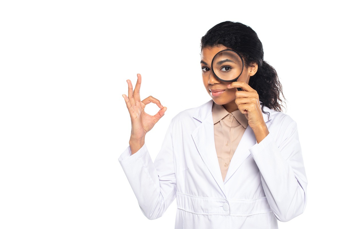 An image of a woman in a white lab coat posing with a magnifier. An image of a woman in a white lab coat posing with a magnifier.