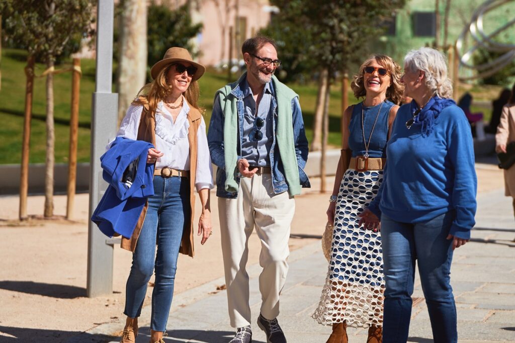 A group of three women and two men walking together on a sidewalk, engaged in conversation, enjoying an eco-tour in the French Riviera