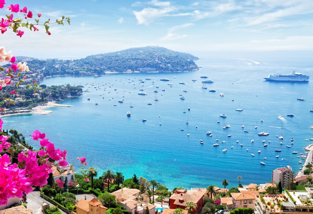 Panoramic vista of Nice's bay showcasing the sparkling sea and various boats dotting the landscape.