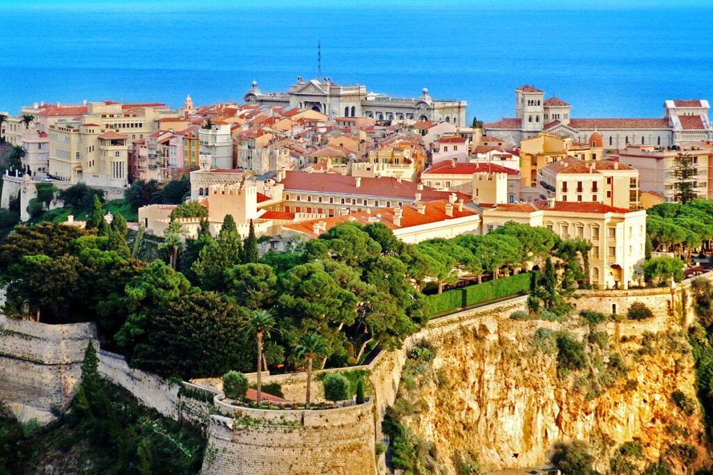 A scenic view of a Monaco-Ville set against a towering cliff, highlighting the blend of urban and natural landscapes. A scenic view of a Monaco-Ville set against a towering cliff, highlighting the blend of urban and natural landscapes.