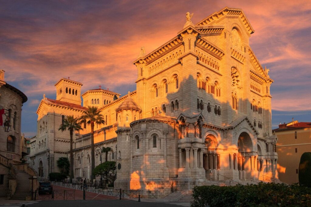 The Monaco Cathedral, France, featuring ornate design elements and a prominent entrance surrounded by greenery. The Monaco Cathedral, France, featuring ornate design elements and a prominent entrance surrounded by greenery.